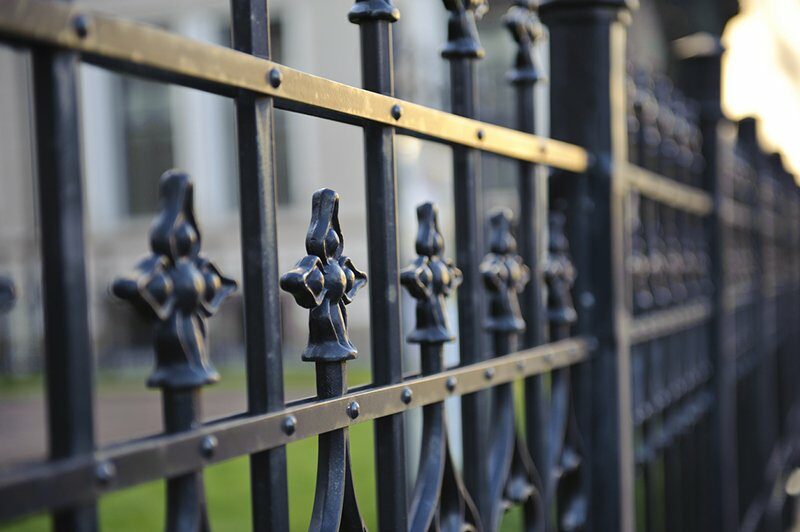 A close up of the iron fence with gold accents.