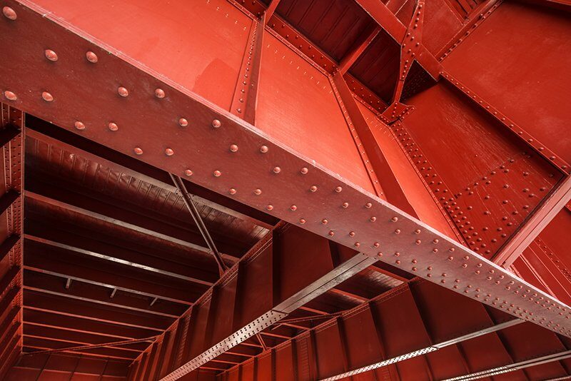 A red metal structure with rivets and bolts.