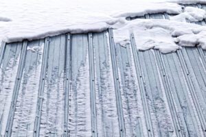 A metal roof covered in snow and ice.