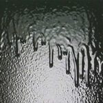 A close up of the water dripping from a window