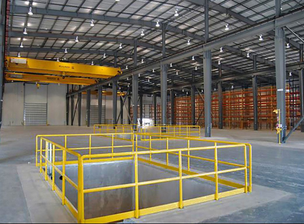 A warehouse with yellow railing and steel beams.