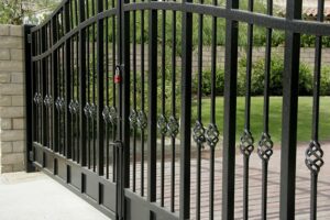 A black metal gate with a fence around it.