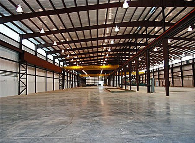 A large warehouse with many metal beams and lights.